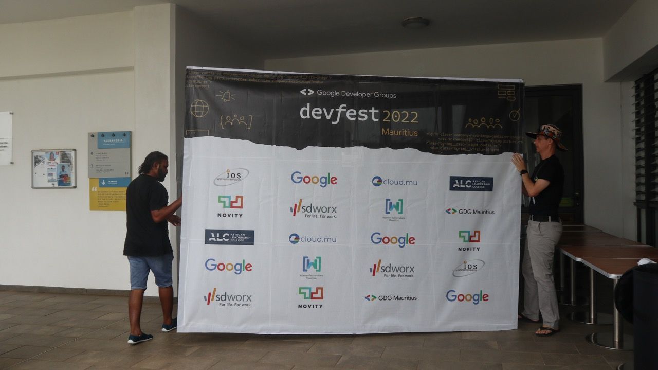 JoKi and Privi setting up the DevFest 2022 backdrop